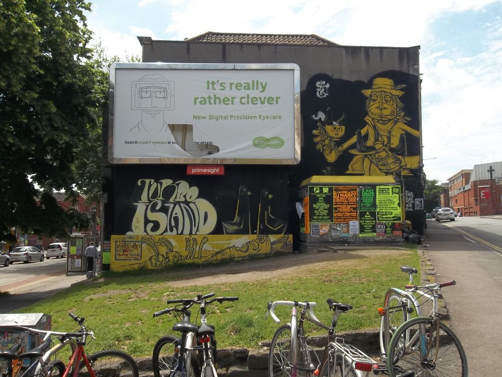 Turbo Island is the piece of land on the corner of Stokes Croft and Jamaica Street. Bombed during the war, it was used for advertising hoardings since the ’50’s. In around 1985, the then Avon County Council sold this land to the advertising company for £32,500, FIVE YEARS AFTER STOKES CROFT WAS DECLARED A CONSERVATION AREA. The land in front of the hoarding was of no interest to the advertisers, and remained a wasteland, largely inhabited by street drinkers and drug addicts. In 2007 PRSC started to make good, floating the then patently absurd notion of Stokes Croft as a Cultural Quarter. Seven years later, the landscape is very different. It is time for this property to come back into community ownership. If you look at the images below, it is hard not to agree that the Community has earned this right. The West Country philosopher John Locke(1632 –1704) in his Second Treatise on Government, asked by what right an individual can claim to own one part of the world, when, according to the Bible, God gave the world to all humanity in common. He answered that persons own themselves and therefore their own labor. When a person works, that labor enters into the object. Thus, the object becomes the property of that person.